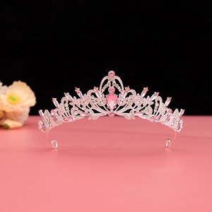 Detail shot of vintage baroque bridal crown with pink teardrop crystal and silver metal