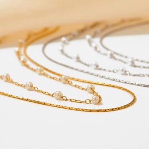 Double-layered stainless steel necklace with white pearls in gold and silver finishes