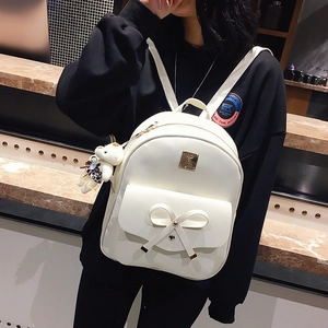 White PU leather backpack with large bow decoration and cute bear pendant on a model