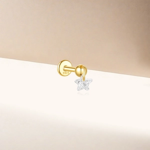 Macro shot of S925 sterling silver gold lotus cartilage piercing with star pendant detail