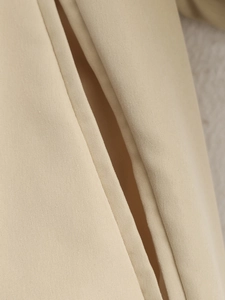 Macro shot of fine stitching on the beige pocket of this French style pleated jacket
