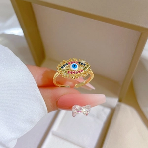 Gold plated evil eye zircon ring with colorful crystals on a warm beige jewelry box