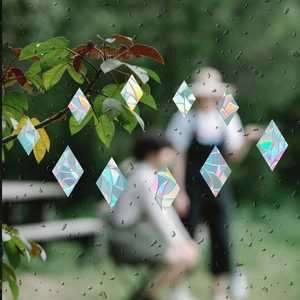 Rainbow prism holographic diamond window sticker with raindrops on glass surface