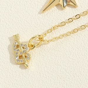 Macro d'un pendentif cœur et flèche plaqué or 14K avec pavé de zircons étincelants