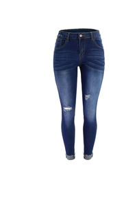 Detalle de vaqueros skinny azules con agujeros desgastados y bajos deshilachados