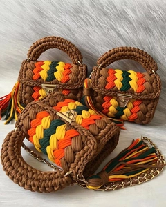 Detailed texture of handmade crochet handbag with striped patterns and metal chain