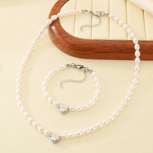 Detail view of heart pendant pearl necklace and bracelet set on a display tray