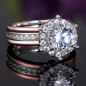 Luxury two-tone halo engagement ring with round zircon on a black reflective surface