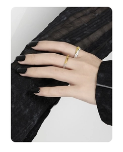 Nahaufnahme von zweifarbigen geometrischen Silberringen an Modelhand mit schwarzem Lack