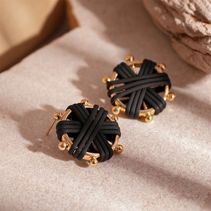 Detailed macro view of woven leather texture on golden round compass stud earrings
