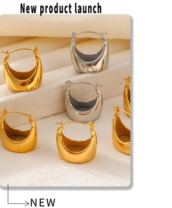 Close-up of sleek gold and silver plated hoop earrings on textured beige display tray