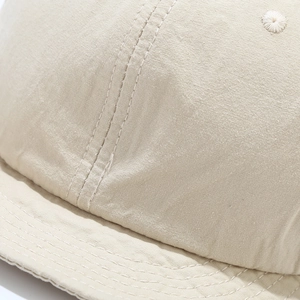 Macro detail of beige cotton-linen cap fabric texture and reinforced stitching line