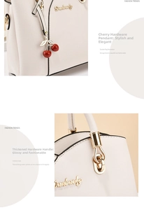 Close-up of creamy white handbag showing cherry charm and gold-tone handle hardware