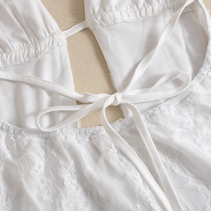 Detailed view of the intricate white lace pattern and back lace-up closure design