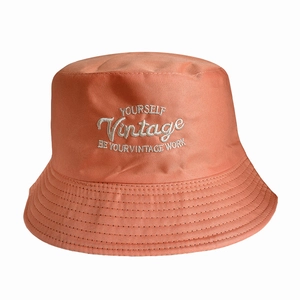 Detailed embroidery of YOURSELF text on a coral twill cotton reversible bucket hat