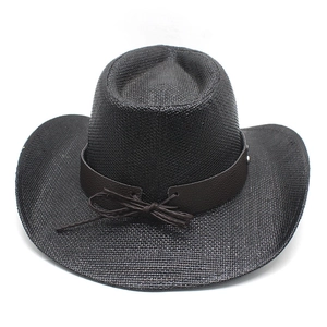 Detailed texture of black woven straw cowboy hat with brown faux leather band and metal studs