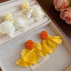 Bohemian acrylic chiffon flower clip-on earrings with beaded centers on velvet tray