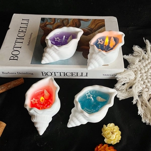 Artistic conch shell scented candle with jelly wax and starfish decor on black background
