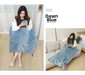 Detail of Dawn Blue flannel blanket with ribbed texture and leather patch on sofa