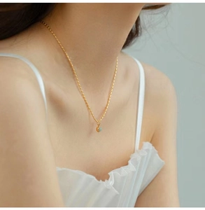 Close-up of Avery green stone pendant necklace on a woman's collarbone in 18K gold finish