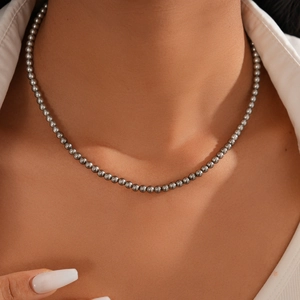 Close-up of elegant dark grey beaded necklace featuring polished metallic luster beads