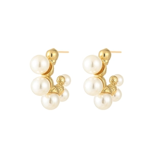 Detail of C-shaped gold pearl earrings featuring alternating sizes of white pearls