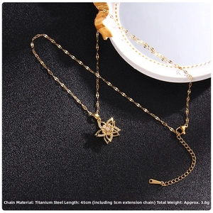 Detail view of rotating four-leaf clover necklace pendant with zircon insets and gold chain