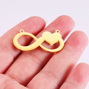 Golden stainless steel infinity heart pendant charm shown on hand for scale