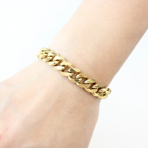 Close-up of a stylish gold Cuban link bracelet on a wrist with polished metal details