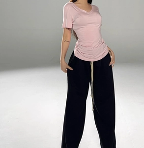 Detail of pink V-neck short-sleeve T-shirt paired with black wide-leg drawstring pants