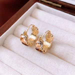 Macro detail of vintage square gold earrings with champagne crystals in a velvet box