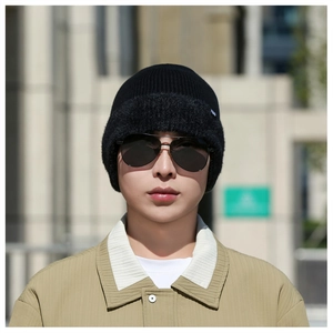 Photo de mannequin en extérieur d'un bonnet en maille noire avec logo discret