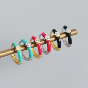 Detail of s925 silver hoop earrings with colorful enamel and zircon on a gold bar