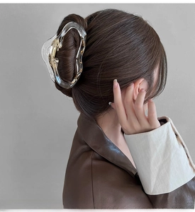 Close-up of a large transparent matte cloud hair claw clip with gold foil on a model