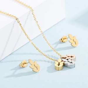 Detailed view of tricolor leaf pendants in gold, silver, and rose gold on a gold chain