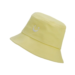 Detail of yellow cotton sun hat featuring high-quality white smiley face embroidery