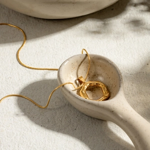 Detail of 18k gold plated stainless steel irregular hammered pendant on a snake chain