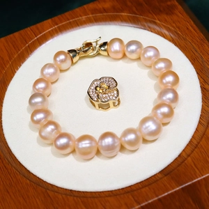 Elegant 8-9mm freshwater pearl bracelet with a rose pendant on white velvet display