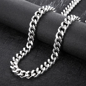 Close-up of a 14mm silver stainless steel Cuban link chain on a black textured surface