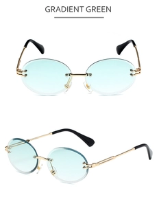 Detail view of rimless oval sunglasses featuring gradient green lenses and gold metal temples