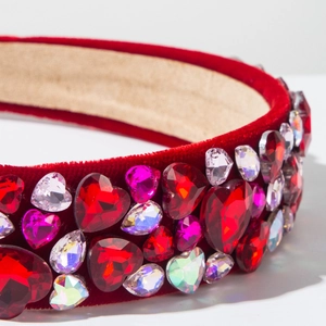 Close-up of wide red velvet headband with colorful heart-shaped crystal embellishments