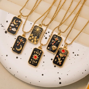 Detail of tarot card pendants with sun moon star patterns and gold twist chain