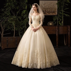 Dettaglio dell'abito da sposa champagne con maniche lunghe e ricami in pizzo raffinato
