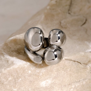 Macro shot of silver molten metal ring with irregular water-drop texture on stone