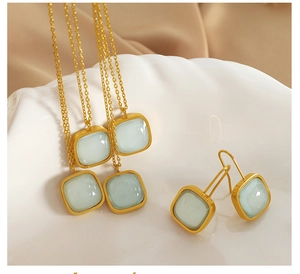 Detail of light blue gemstone necklace and earrings set on a white shell tray