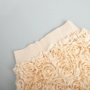 Macro shot of 3D rose fabric details and elastic waistband on beige evening skirt
