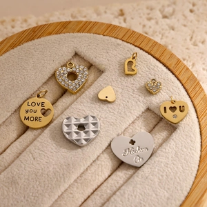 Ciondoli a cuore lucidi in oro e argento con incisioni LOVE in un portagioie