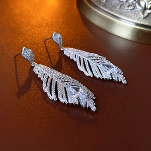Vue macro de boucles d'oreilles feuilles avec finition argentée et zircons brillants