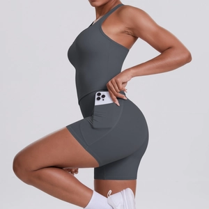 Detail of dark grey yoga romper featuring a functional side pocket holding a smartphone