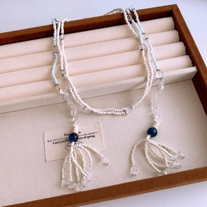 Close-up of bohemian beaded necklace with fringe tassel on a professional display
